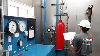 An employee applying a fire suppression system to a business in Charlotte, NC